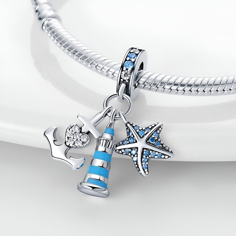 Charm pendentif en argent avec phare bleu et blanc, étoile de mer bleue et ancre élégante sur bracelet serpent.