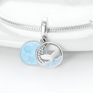 Charm pendentif argent avec queue de baleine et cercle bleu océan texturé sur bracelet serpent.
