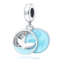 Charm pendentif en argent avec queue de baleine, strass, et disque bleu marin éclatant.