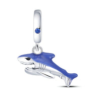Pendentif charm requin argenté avec nageoire bleue et œil bleu, design détaillé et moderne.