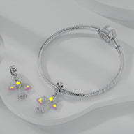 Bracelet argenté avec pendant signe zodiaque Balance orné d'étoiles jaunes et détails roses.