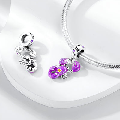 Pendentif charme signe zodiacal Balance en argent avec émail violet et détails étoiles, sur chaîne serpent argentée.