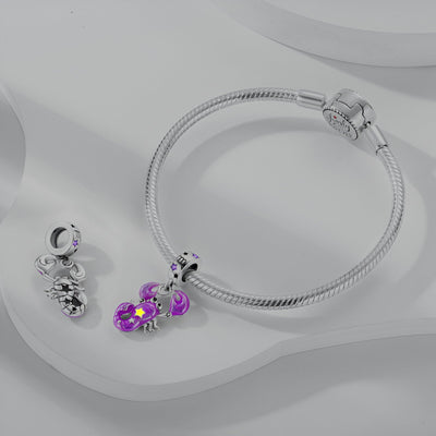 Bracelet argenté avec pendant charme signe Balance violet et deux breloques argentées supplémentaires.