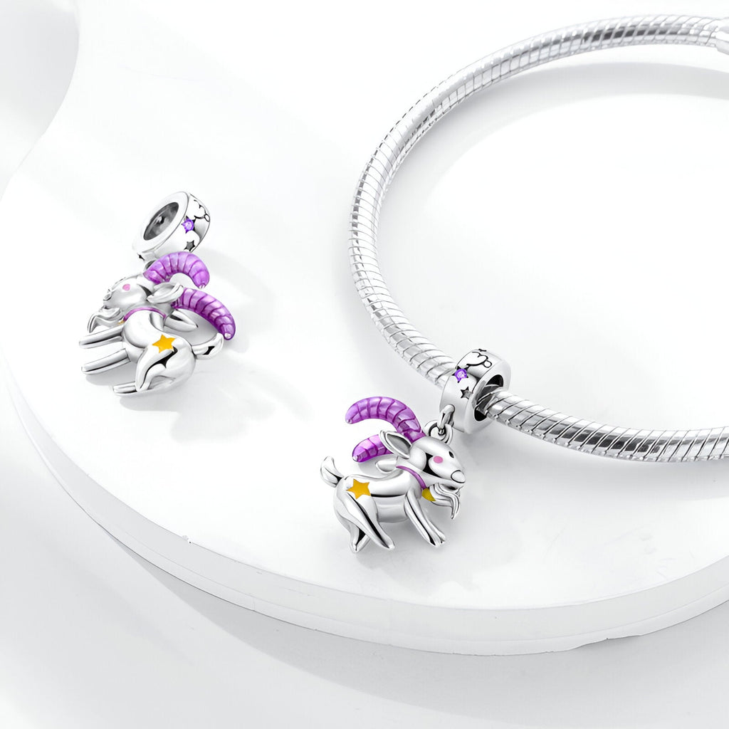 Charm pendentif Capricorne argent avec cornes violettes et détails dorés sur bracelet serpent.