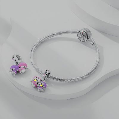 Bracelet argenté rigide avec pendentif signe Gémeaux rose et violet décoré de cristaux éclatants.