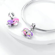 Charm pendentif Gémeaux en argent avec émail rose et violet, détails étoiles et lune, monté sur bracelet serpent argenté.
