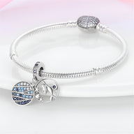 Bracelet argenté avec pendentifs sirène et globe bleu ornés de cristaux scintillants.