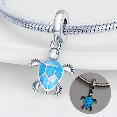 Charm pendentif tortue bleue en argent avec détails gravés, montage sur bracelet serpent argenté.