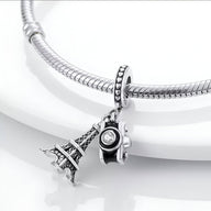 Charm pendentif argenté Tour Eiffel et appareil photo avec strass sur bracelet serpent argenté.