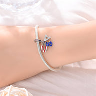 Bracelet argenté avec pendentif drapeau américain, étoile et trèfle bleu, style délicat.