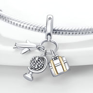 Charm pendentif en argent avec globe, avion et valise dorée, style voyage élégant.