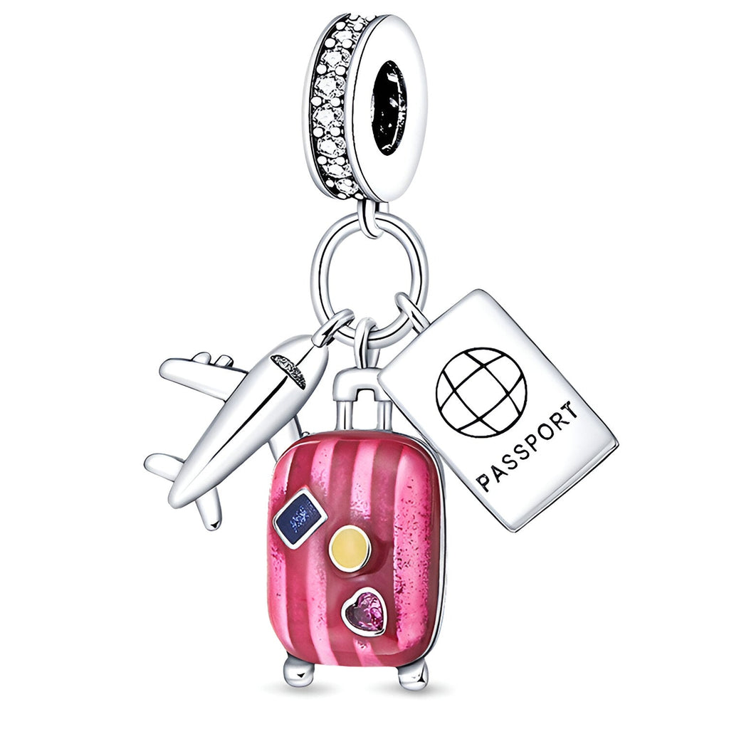 Charm pendentif argent avec valise rose, passeport blanc et avion argenté, détails couleurs vives.
