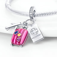 Charm pendentif en argent avec valise rose, passeport gravé et avion, style voyage.