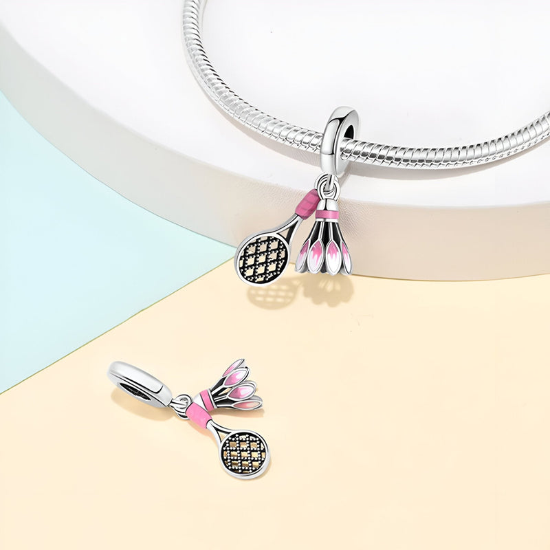 Charm argent avec volant de badminton rose et raquette détaillée, style délicat et féminin.