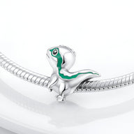 Charm dinosaure argenté avec détails verts scintillants pour bracelet à maillons.