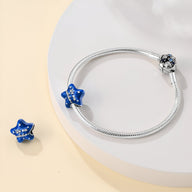 Bracelet argenté avec charm étoile bleu foncé orné de petits cristaux blancs.