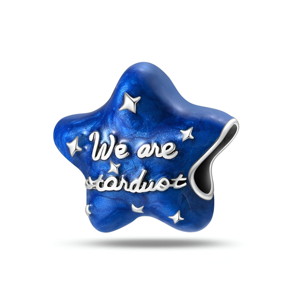 Charm étoile bleu nuit en métal avec inscriptions argentées « We are stardust » et petites étoiles.