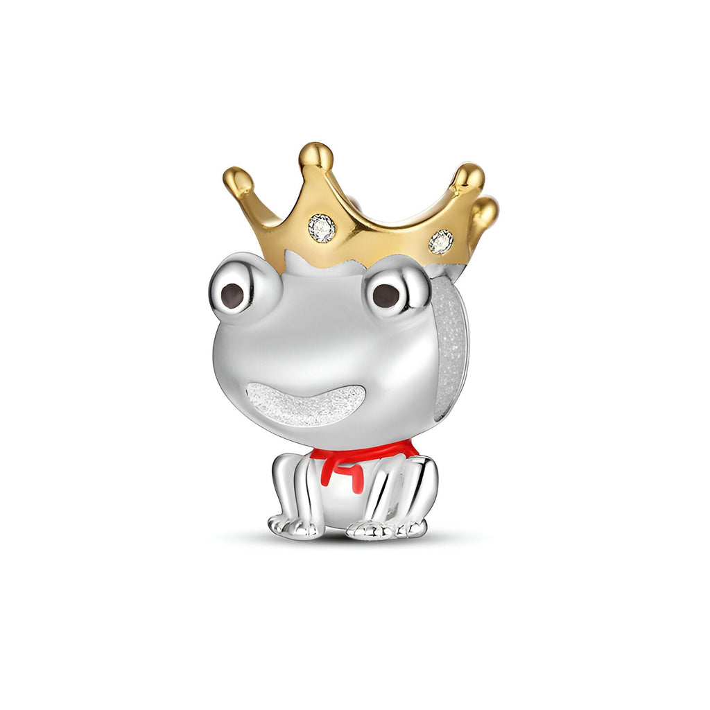 Charm grenouille argentée avec couronne dorée et yeux expressifs, détail rouge sous la tête.