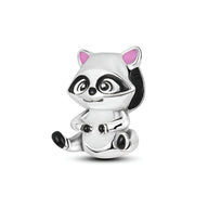 Charm raton laveur en métal argenté avec détails noirs et intérieurs d'oreilles roses.