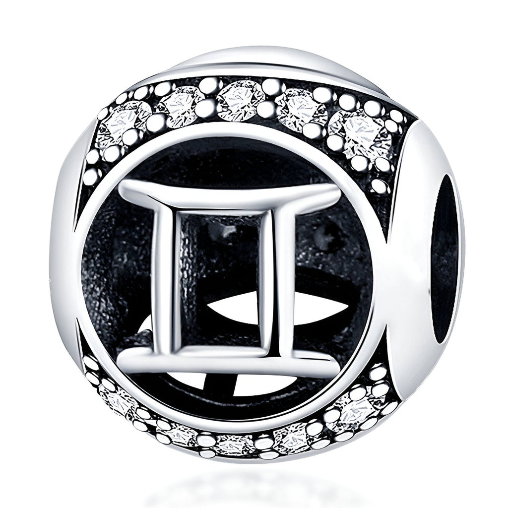 Charm rond en argent avec symbole gémeaux et contour orné de petits cristaux blancs.