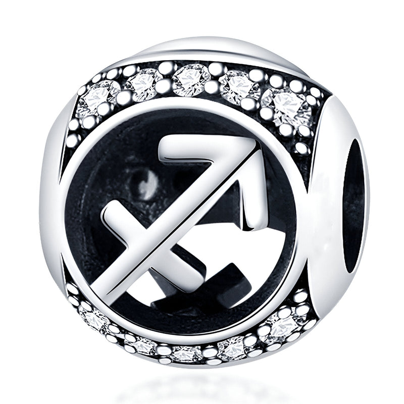 Charm rond en argent avec symbole sagittaire gravé et bordure ornée de petites pierres blanches scintillantes.
