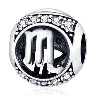 Charm rond en argent avec signe du zodiaque Scorpion et bordure ornée de petits cristaux blancs.