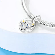 Charm rond en argent avec constellation du Capricorne et étoiles jaunes sur bracelet serpent.