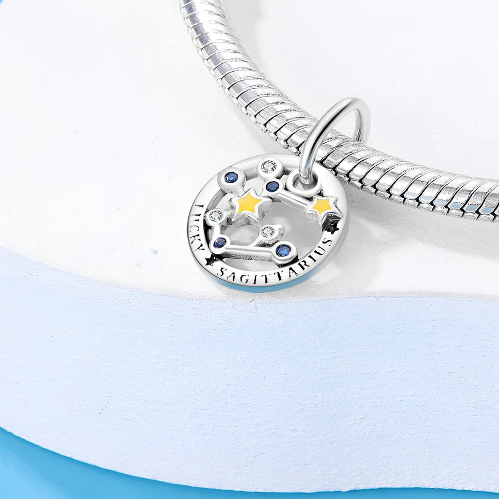 Charm argenté signe Sagittaire avec étoiles dorées et bleues, chaîne serpent brillante.