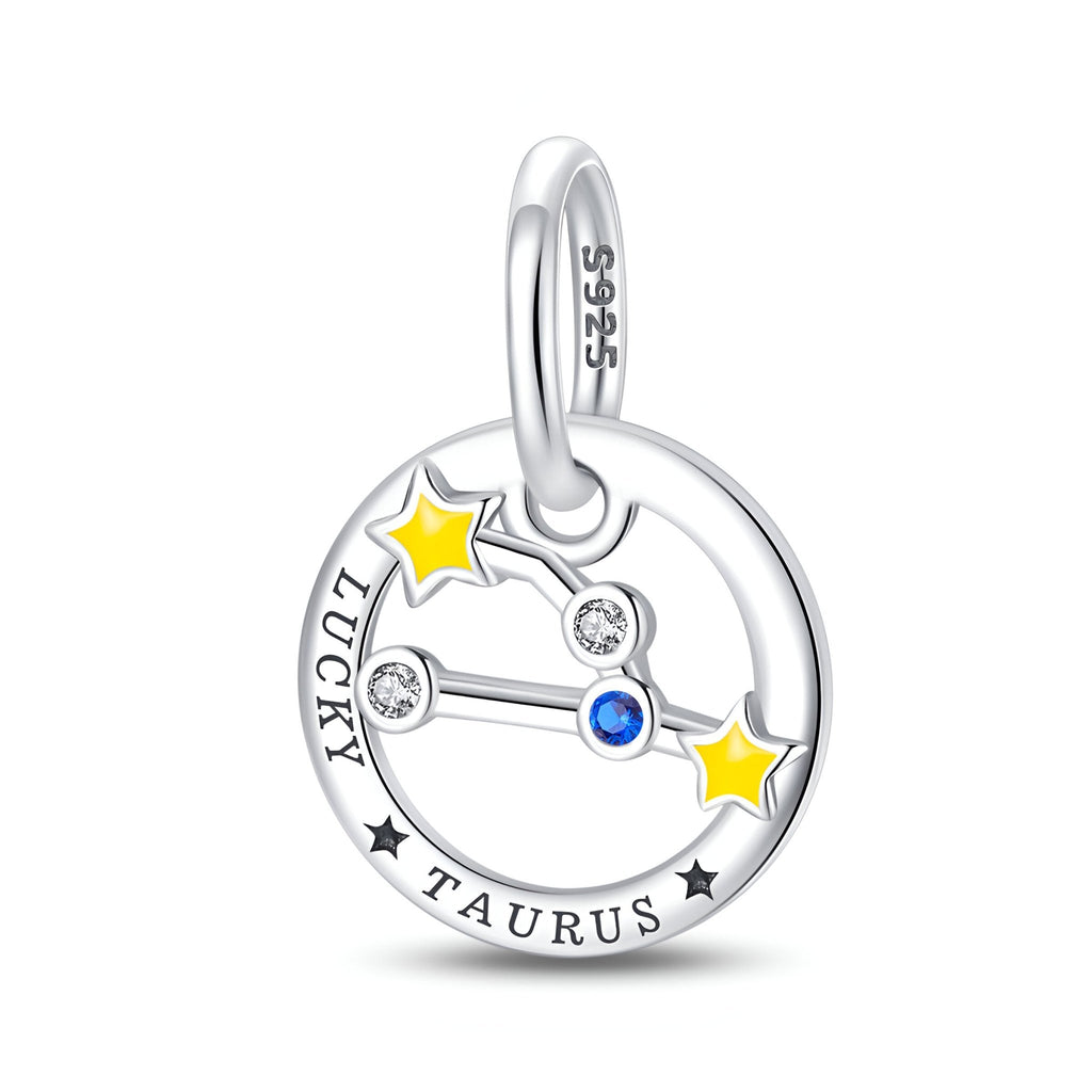 Charm rond en argent avec constellation Taureau, deux étoiles jaunes, pierres blanches et bleue, gravure "Lucky Taurus".