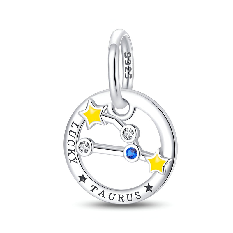 Charm rond en argent avec constellation Taureau, deux étoiles jaunes, pierres blanches et bleue, gravure "Lucky Taurus".