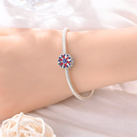Bracelet argent avec charm tournesol rouge, blanc et bleu à centre étoilé.