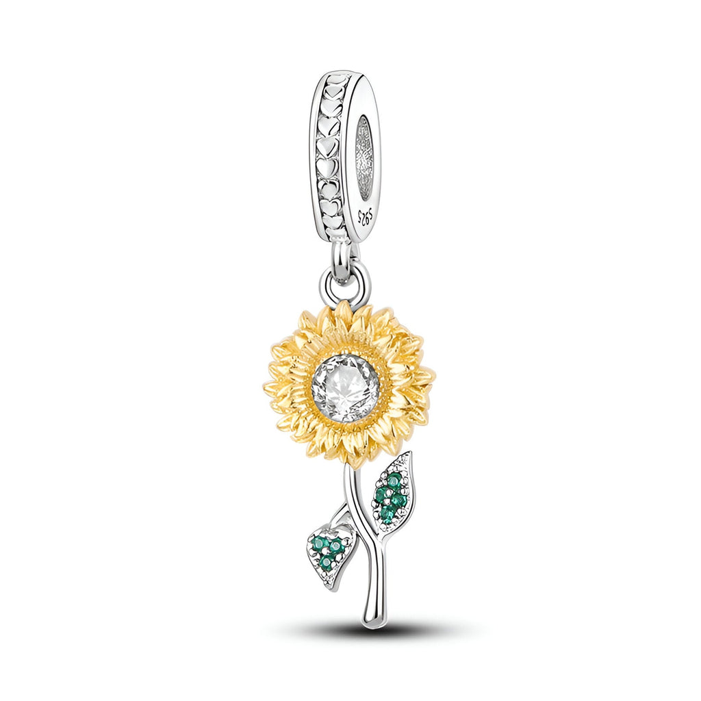 Charm pendentif tournesol doré avec pierre centrale claire et tige argentée ornée de feuilles vertes.