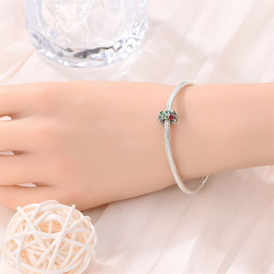 Charm argenté avec trèfle à 4 feuilles vert et coccinelle rouge sur bracelet fin argenté.