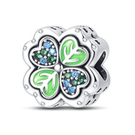 Charm trèfle à 4 feuilles en argent avec détails verts et pierres bleues scintillantes.
