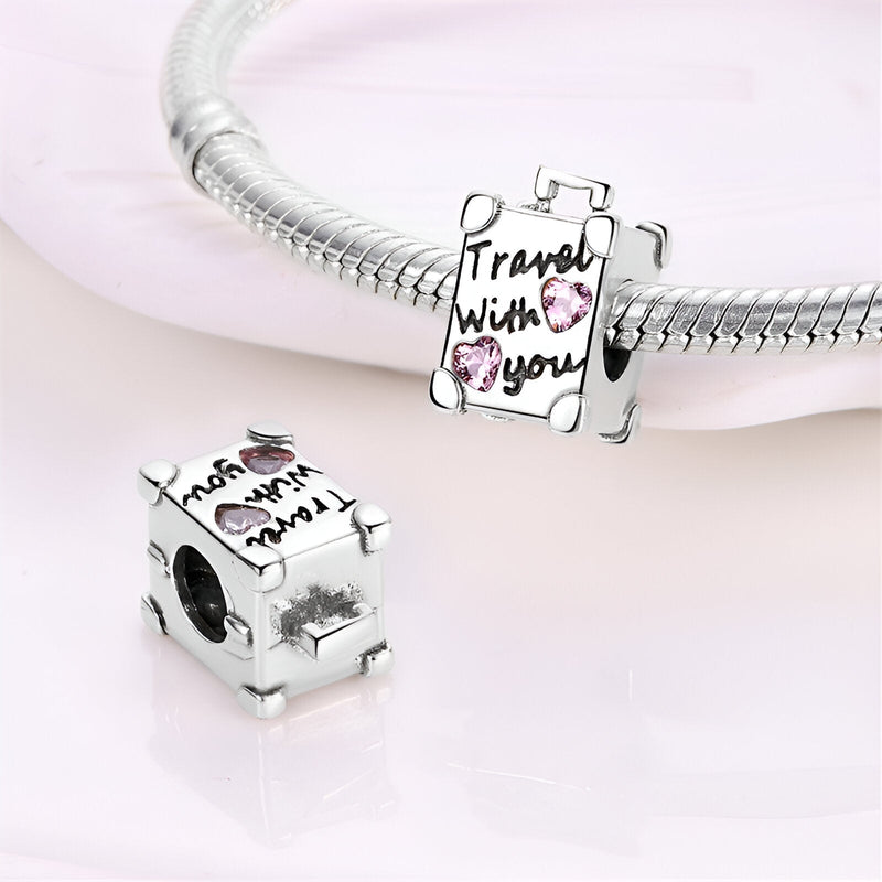 Charm valise en argent avec texte "Travel with you" et cœur rose, modèle Belicia.