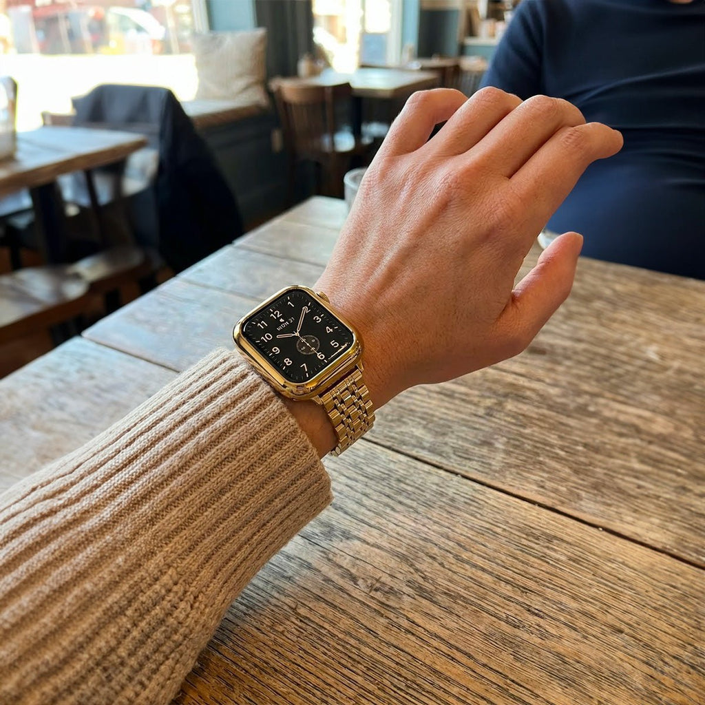 Coque intégrale en acier inoxydable doré brillant pour Apple Watch avec bracelet à maillons et fermeture déployante raffinée.