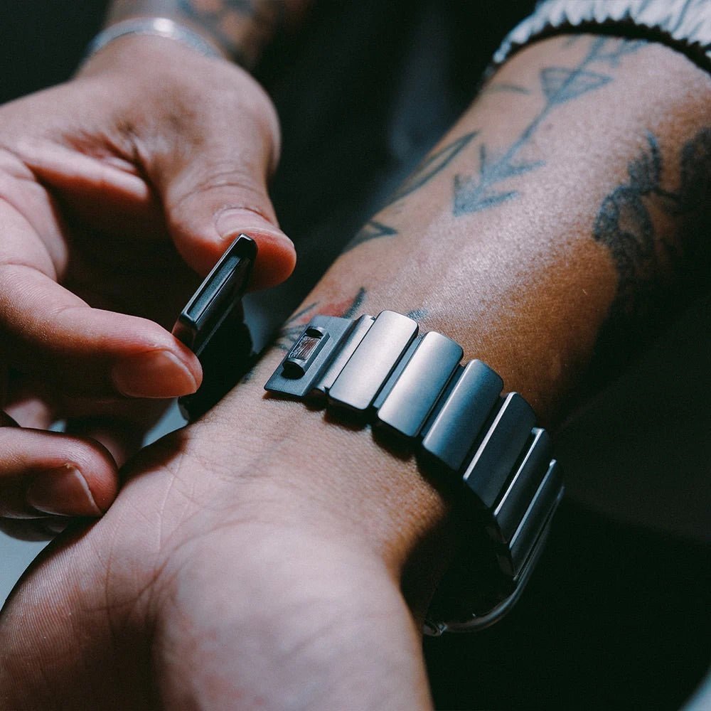Bracelet Apple Watch en titane grade 4 gris mat avec fermoir robuste et design élégant, porté au poignet.