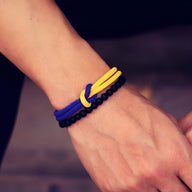 Duo de bracelets cordon bleu et jaune avec perles d'onyx noir et nœud central.