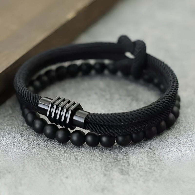 Duo de bracelets noirs en cordon avec perles d’onyx mat et noeud central métallique noir.