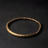 Bracelet mixte en cuivre martelé et perles bois marron sur fond noir.