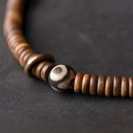 Bracelet marron en bois avec perle centrale en pierre d'agate naturelle marron clair et beige.