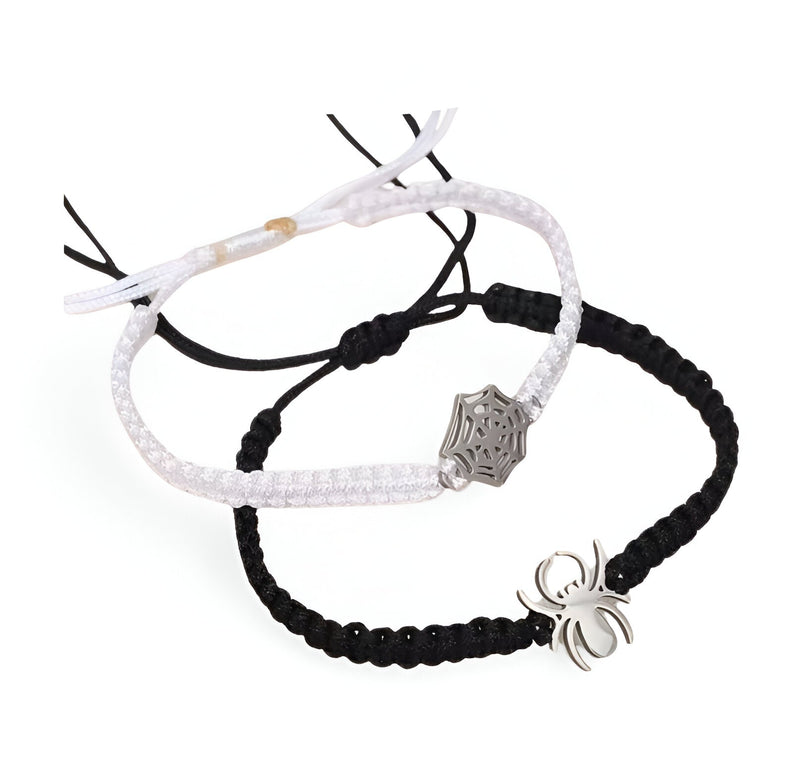 Duo de bracelets cordon blanc et noir avec pendentifs araignée en métal argenté.