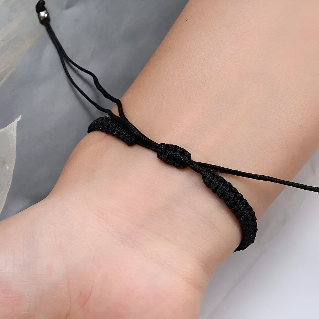 Bracelet cordon noir tressé avec fermoir coulissant ajustable pour poignet.