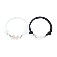 Duo de bracelets cordon noir et blanc avec pendentifs cœur et papillon en métal argenté.