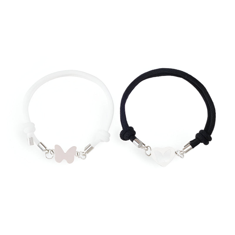 Duo de bracelets cordon noir et blanc avec pendentifs cœur et papillon en métal argenté.