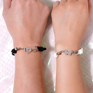 Duo de bracelets cordon noir et blanc avec pendentifs en forme de cœur et papillon en métal argenté.