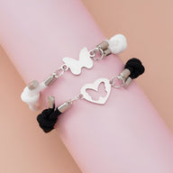 Duo de bracelets cordon noir et blanc avec pendentifs métal cœur et papillon élégant.