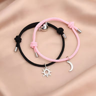 Duo de bracelets cordon rose et noir avec pendentifs soleil et lune en argent.