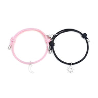Duo de bracelets cordon rose et noir avec pendentifs lune argentée et soleil argenté.