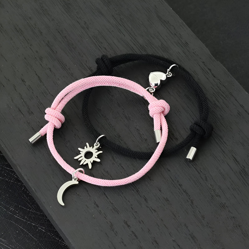 Duo de bracelets cordon rose et noir avec pendentifs soleil argenté et lune suspendus.